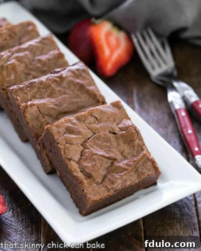 Fudgy Brownies from Scratch on a white ceramic tray, showcasing their rich, dark color and perfect texture.