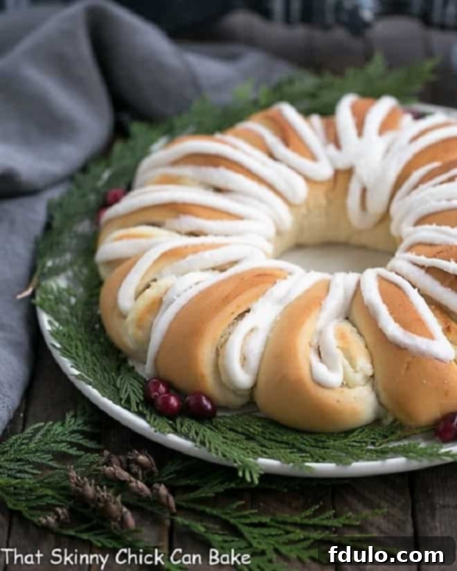 Cream Cheese Tea Roll on a white plate garnished for Christmas with cranberries and evergreen.