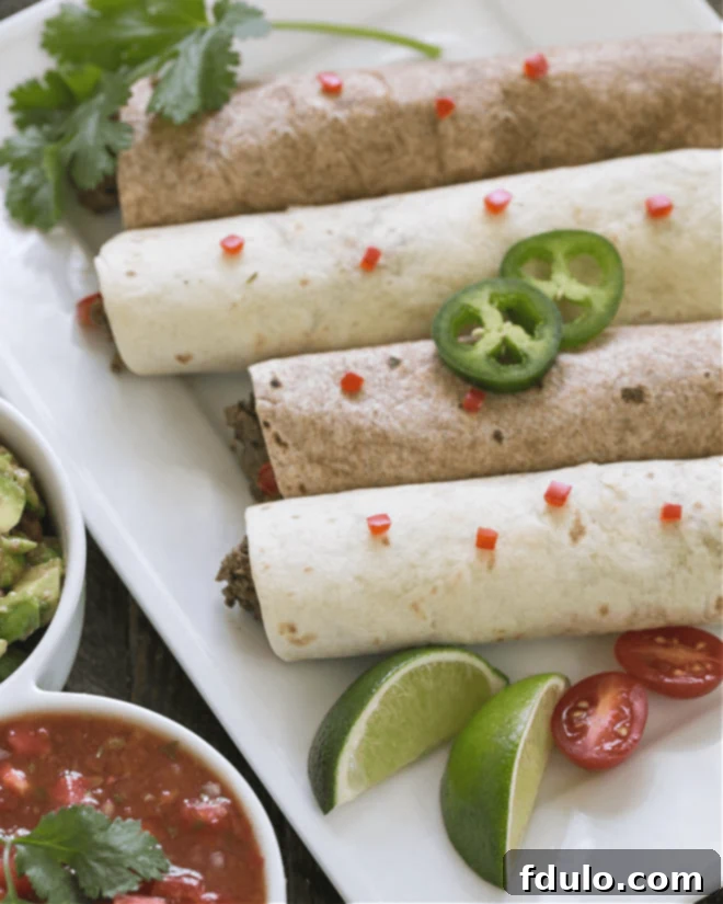 Overhead view of soft shell beef tacos on a white platter, perfectly garnished and ready to eat.