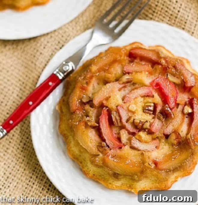 Fresh Rhubarb Cakes - a delicious way to enjoy spring rhubarb for dessert! Who can resist their own rhubarb upside down cake?? Fresh Rhubarb Upside-down Baby Cakes on a white dessert plate with a red handled fork, ready to be enjoyed.