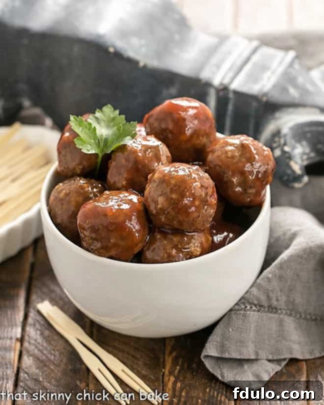 Cranberry Baked Meatballs in a white bowl with toothpicks, ready for serving.