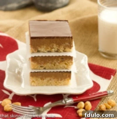 Neatly stacked Chocolate Peanut Butter Krispie Bars on a square white plate, showcasing their clean edges.