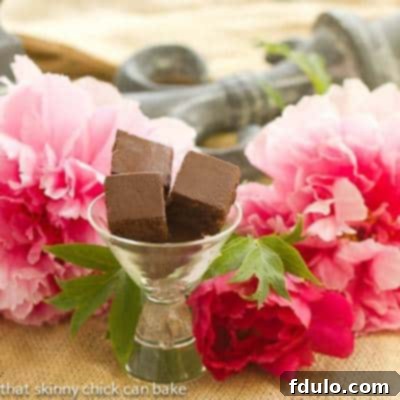 Four rich and fudgy Refrigerator Brownies in a glass, beautifully arranged with pink peonies.