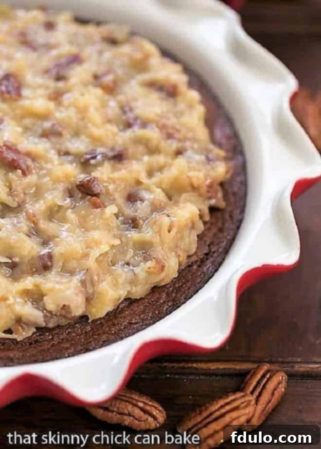 A stunning German Chocolate Brownie Pie in a ruffle-edged pie plate, garnished with pecan halves, ready to be sliced.