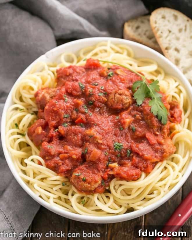 Overhead view of a homemade pasta sauce recipe over spaghetti