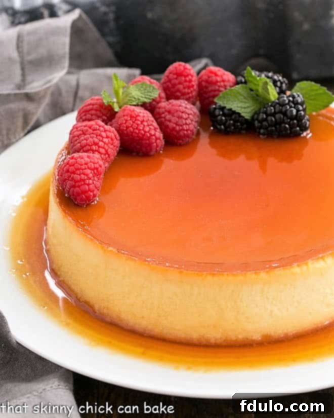 Flan Recipe topped with fresh berries on a pristine white plate, showcasing its golden caramel sheen.