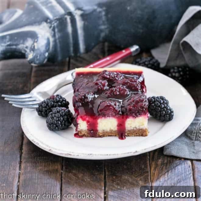 Black berry Topped cheesecake bar with fresh blackberries on a round white plate