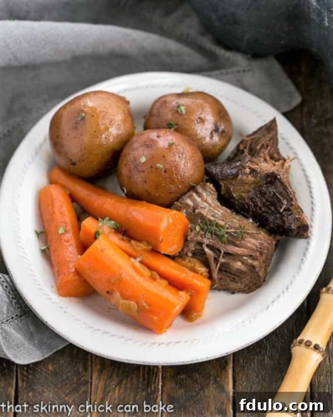 Overhead view of Instant Pot Beef Stew on a white plate, garnished with fresh herbs.