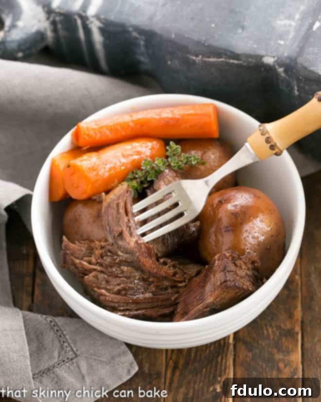 Pressure cooker beef stew in a white bowl with a fork piercing a piece of tender stew meat, showing carrots and potatoes.