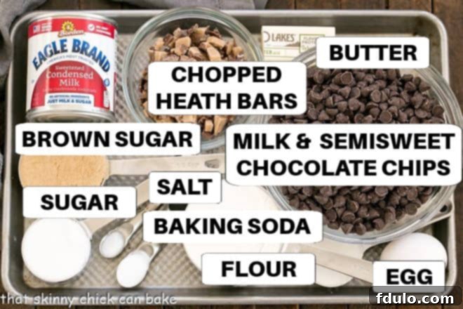 Individual ingredients for Fudge and Toffee Filled Chocolate Chip Bars, neatly labeled and laid out on a metal sheet pan.