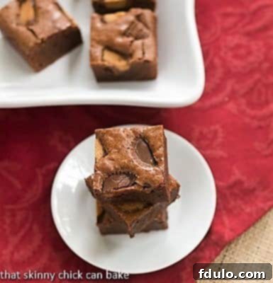 Fudgy Brownies with Reese's Chunks - the ultimate chocolate peanut butter delight Stack of rich, fudgy brownies with visible Reese's peanut butter cup chunks on a small white plate, ready to be enjoyed