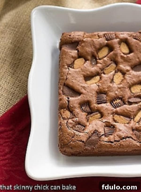 Perfect for any occasion, these fudgy brownies combine rich chocolate with creamy Reese's peanut butter goodness. Close-up of Fudgy Brownies with Reese's Chunks artfully arranged on a serving tray, showcasing their rich texture and vibrant peanut butter cup pieces