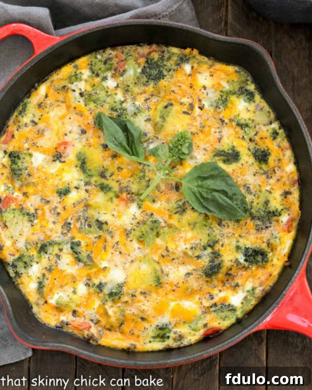 Overhead view of roasted broccoli frittata in a red cast iron pan.