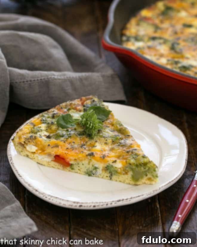 slice of broccoli frittata on a white plate in front of red cast iron pan