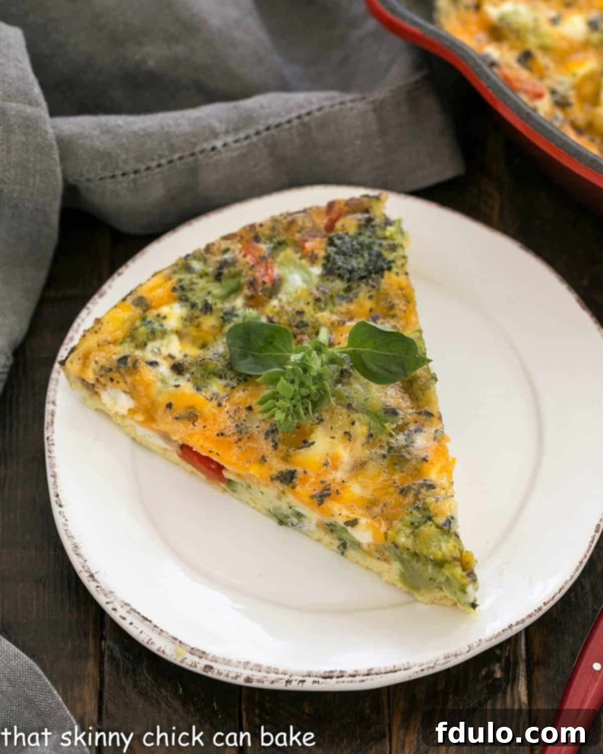 Overhead view of slice of broccoli frittata on a round white ceramic plate.