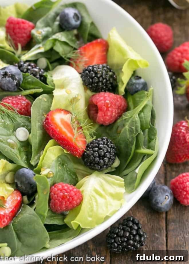 Close view of spinach salad ingredients in a white bowl.