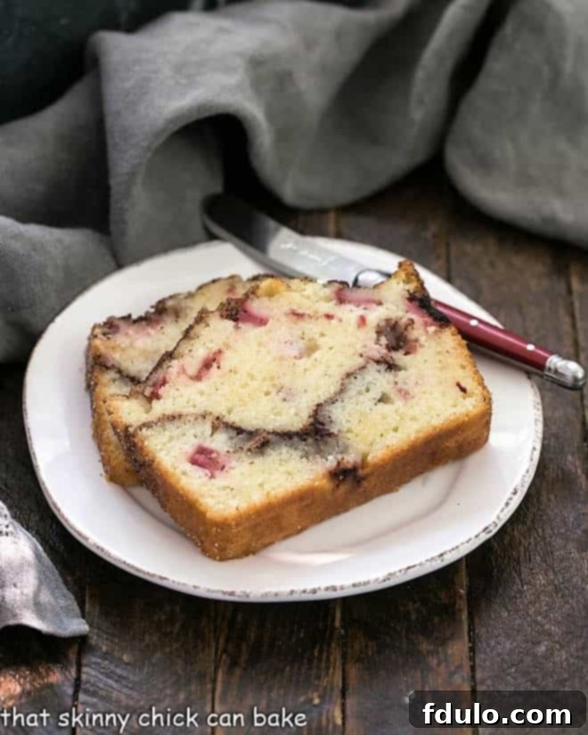Two thick slices of delicious Cinnamon Swirl Rhubarb Bread arranged on a delicate round white plate.