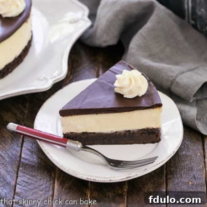 Slice of brownie cheesecake on a white dessert plate with a red handle fork