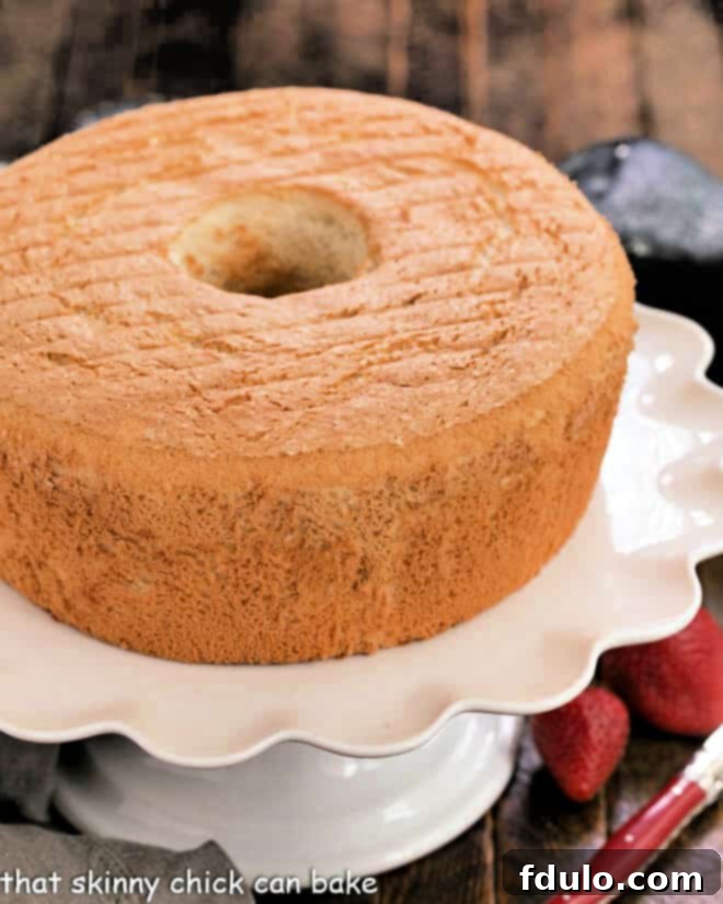 Whole angel food cake on a white cake stand.