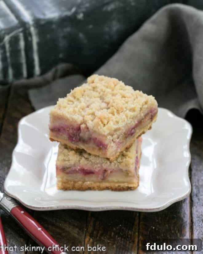 Streusel Topped Rhubarb Bars stacked on a square white plate