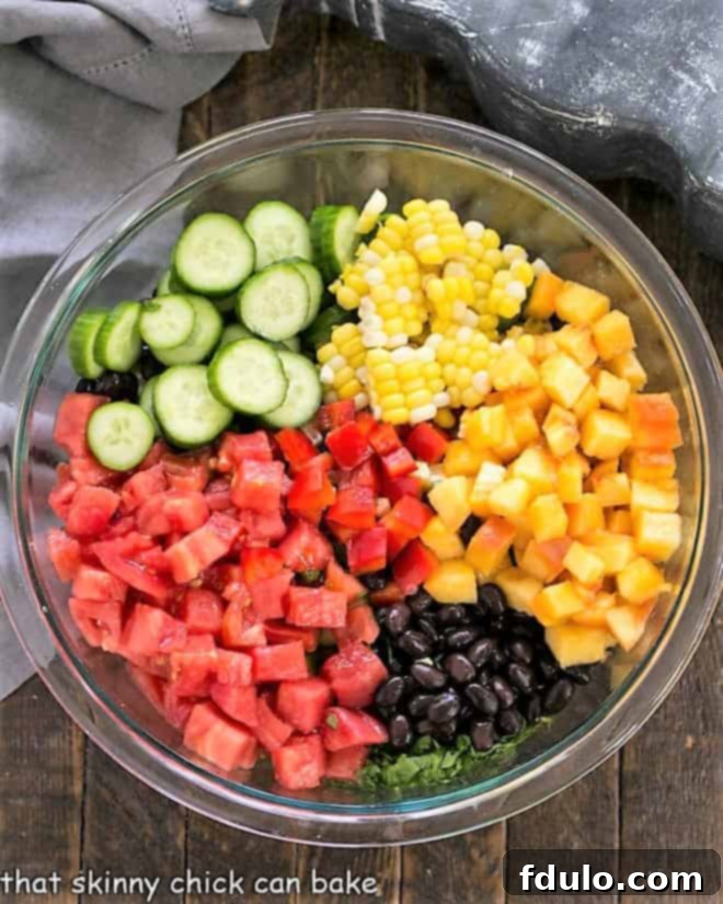 Southwest Fiesta Salad 2 Close-up of freshly chopped salad ingredients like sweet corn, red bell peppers, and diced tomatoes, arranged neatly next to a small bowl of cilantro-lime vinaigrette.