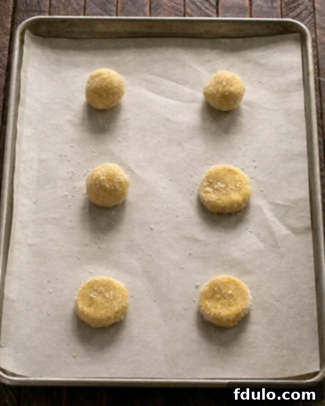 Step 5: Scoop large dough balls, roll them in coarse sugar, then slightly flatten before baking.