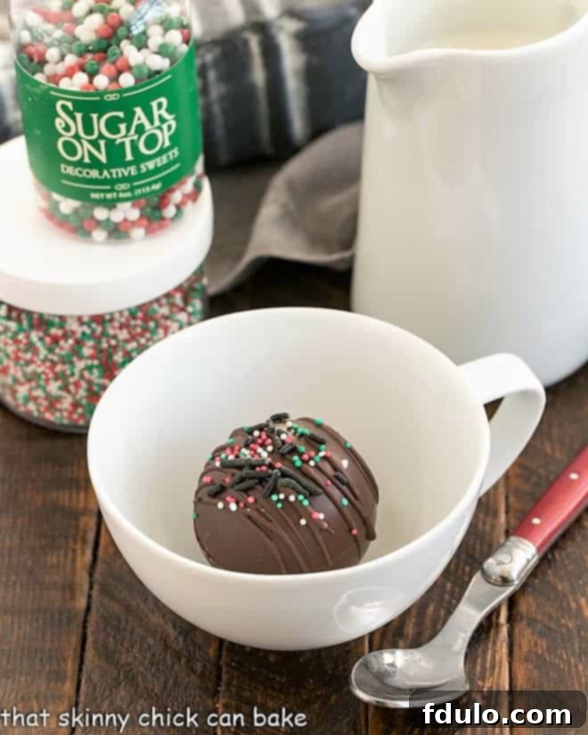 A hot chocolate bomb resting gracefully in a white teacup, awaiting the pour of hot milk.