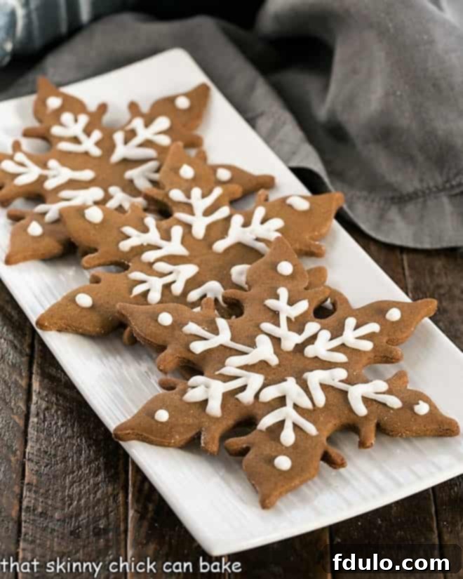 The Ultimate Guide to Gingerbread Perfection 2 Three beautifully decorated gingerbread snowflakes resting on a pristine white platter, evoking a sense of festive elegance and homemade charm.