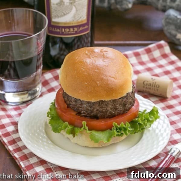 California burger on a white plate over a checked napkin, showing the perfectly grilled patty and fresh toppings