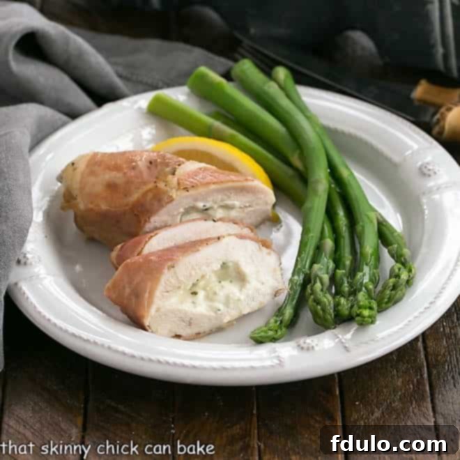Creamy Boursin Stuffed Chicken Breasts 2 Bousin chicken breast sliced on a white plate with aspargus spears