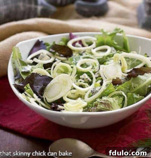Vibrant Fennel and Gorgonzola Salad served in a pristine white bowl, showcasing thinly sliced fresh fennel and creamy Gorgonzola