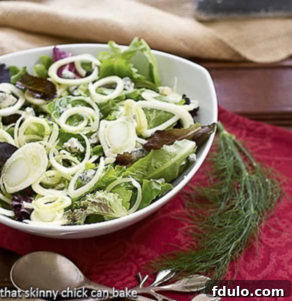 Close-up of Fennel and Gorgonzola Salad in a serving bowl, garnished with a delicate fennel frond, highlighting the texture and freshness