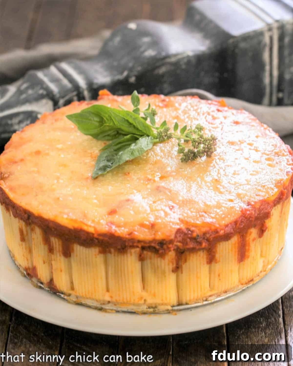 Rigatoni Bake on a white serving plate, showing a wedge portion with melted cheese.