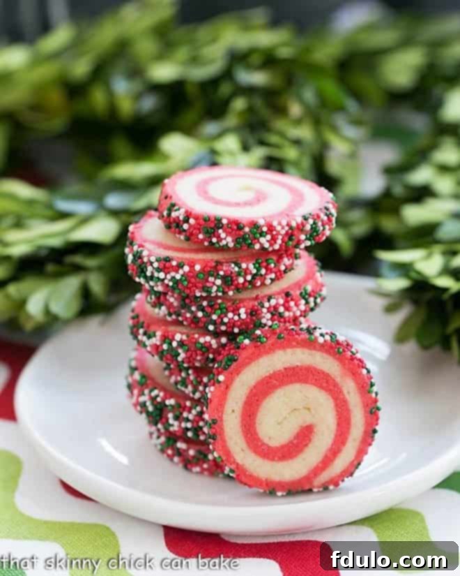 Holiday Pinwheel Cookies beautifully stacked on a small round white plate, presenting a festive and perfect homemade edible gift.