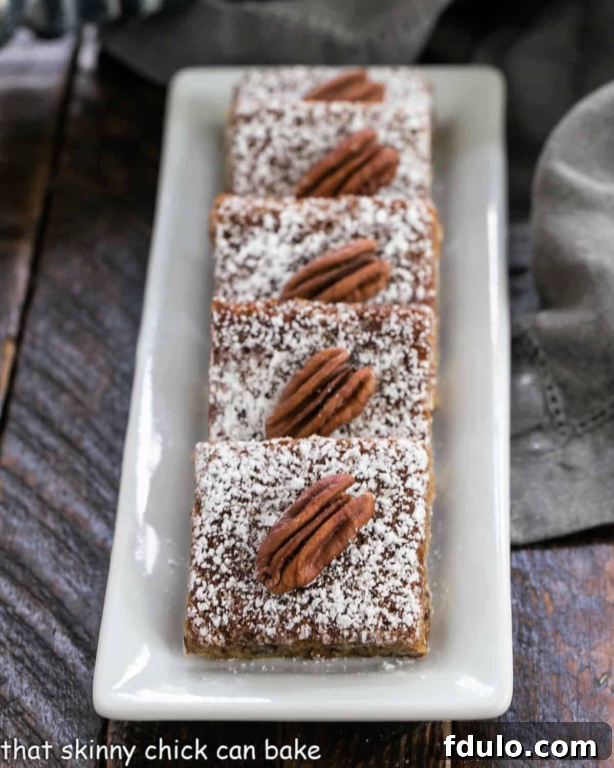 Pecan squares lined up on a white tray.