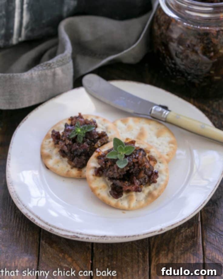Bacon jam on crackers on a white appetizer plate