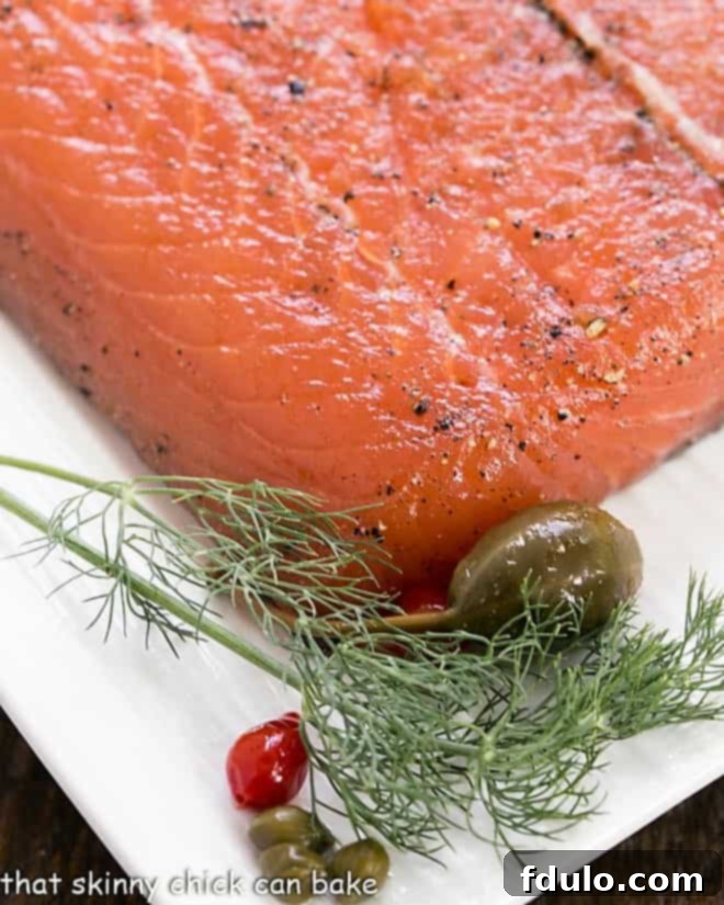 Close up of gravlax on a white platter with dill garnish.