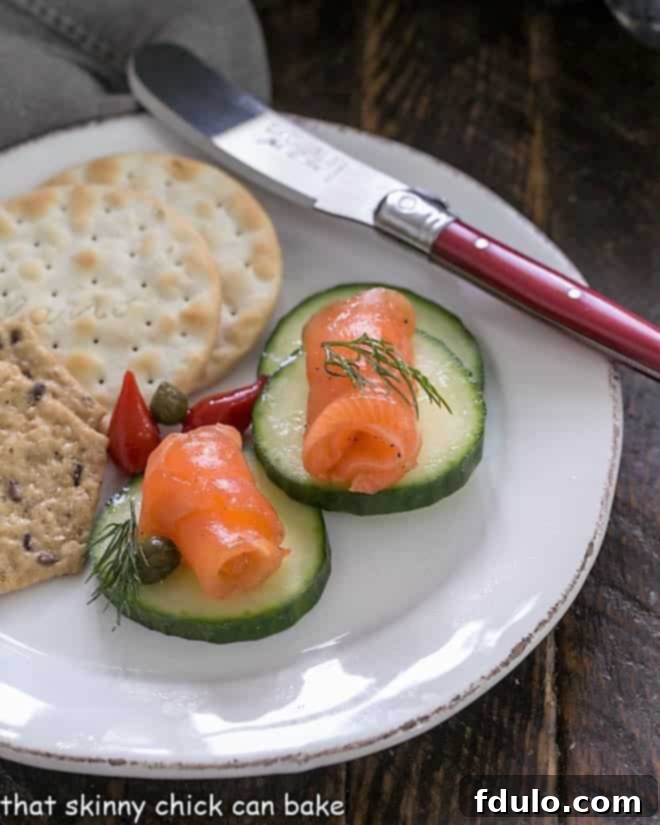 Gravlax on cucumber slices on a white appetizer plate.