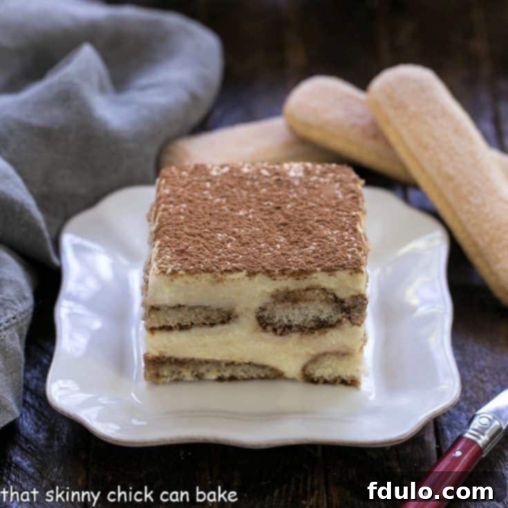 Unlock the Secret to Perfect Tiramisu 7 A slice of classic tiramisu on a square white plate with 2 ladyfingers