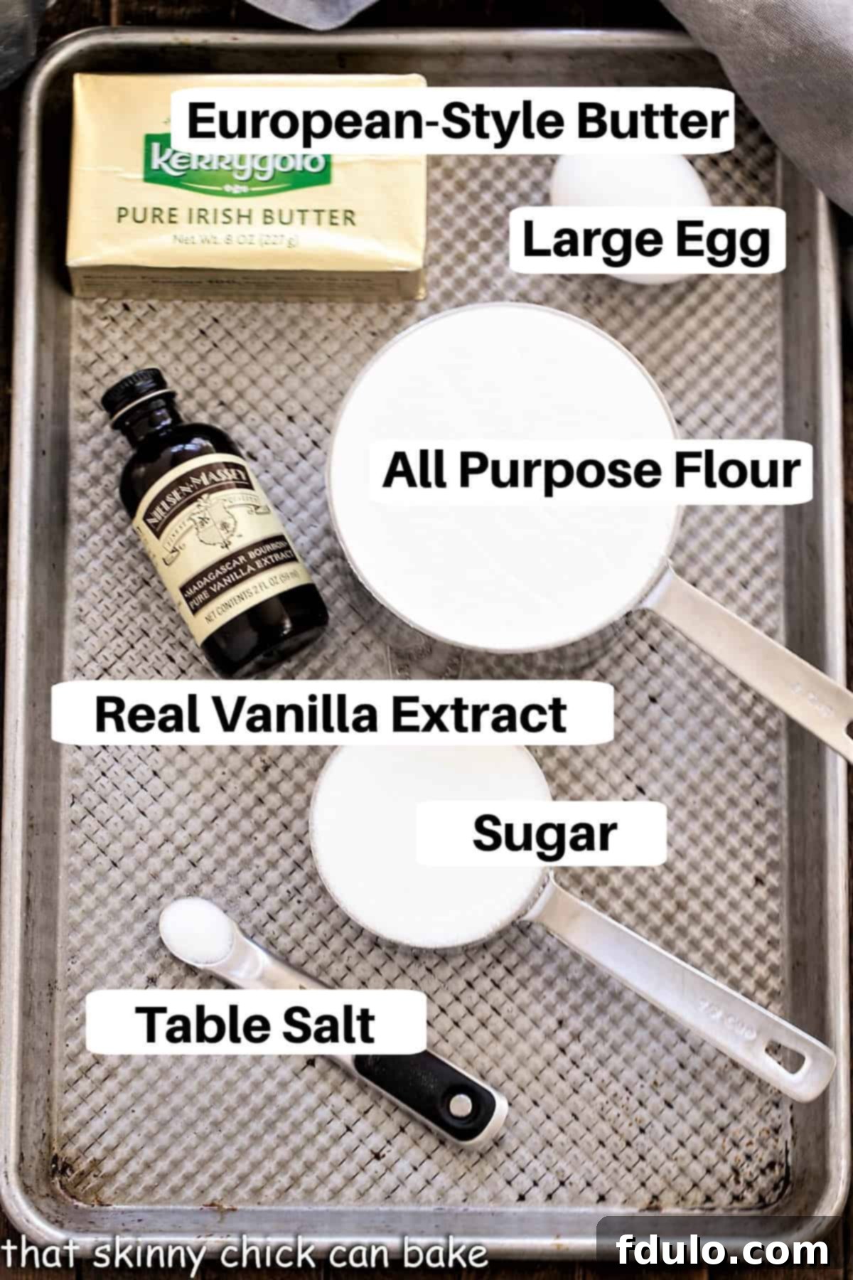 An array of fresh, high-quality ingredients for Danish butter cookies, neatly arranged on a baking sheet, each labeled clearly.