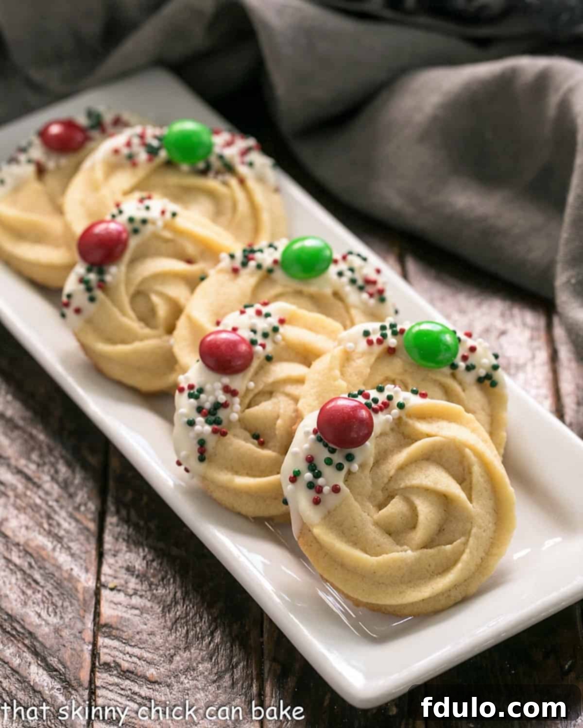 A selection of beautifully decorated Danish Butter cookies arranged on a pristine white serving tray, showcasing various garnishes.