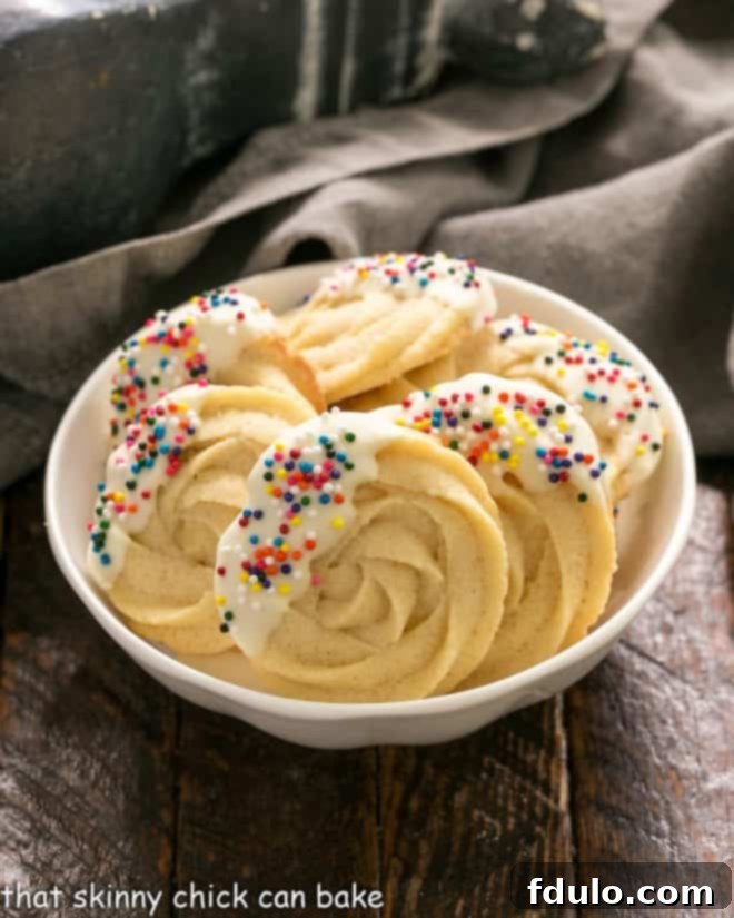 A rustic white bowl overflowing with freshly baked, golden Danish Butter Cookies, ready for enjoyment.