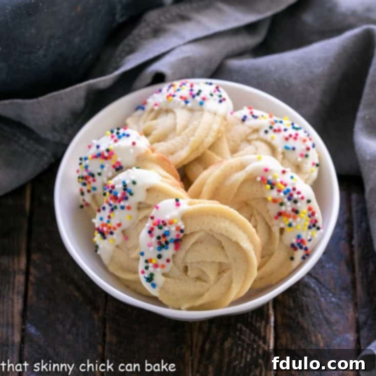 A stunning array of Danish Butter Cookies arranged in a pristine round white bowl, perfect for sharing.