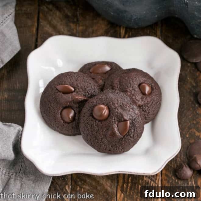 Overhead view of four rich Double Chocolate Cookie Bites on a pristine square white plate, perfectly baked and ready to enjoy.