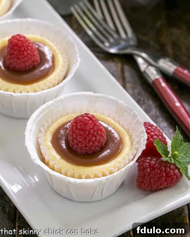 Individual Caramel Cheesecakes - An exquisite combination of flavors and textures in these individual cheesecakes! Two Caramel Topped Mini Cheesecakes beautifully arranged on a white tray, ready to be served.