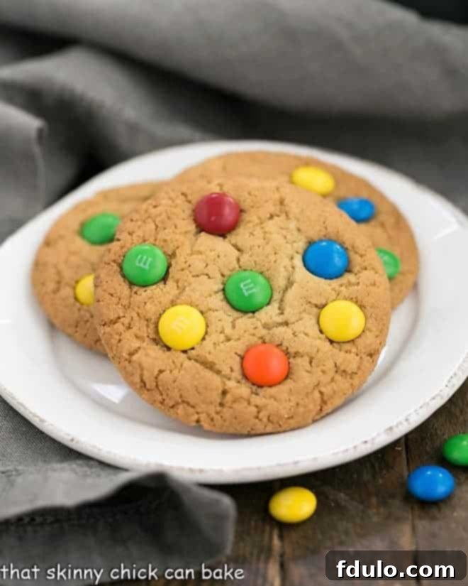 Classic M & M Cookies on a round white plate, showcasing their soft texture and colorful candies.