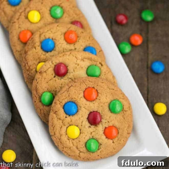 Classic M & M Cookies on a white ceramic tray, showcasing their vibrant colors and perfect roundness.