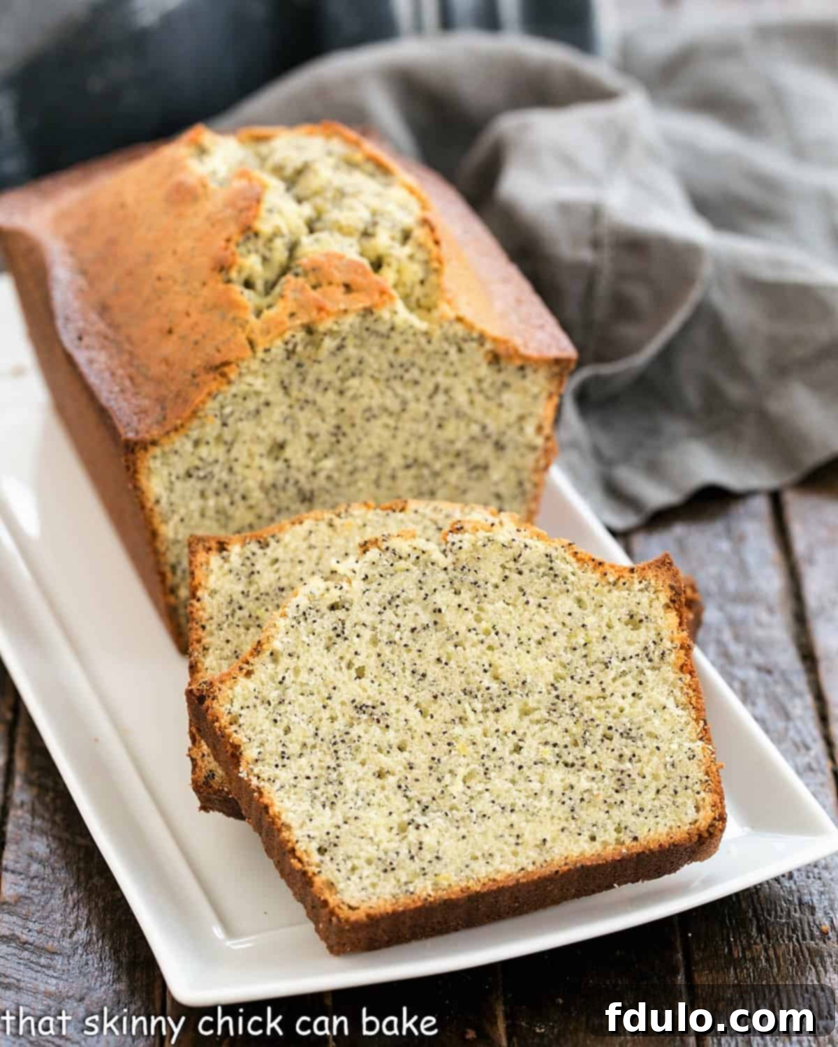 Sliced lemon poppy seed loaf on a ceramic tray.