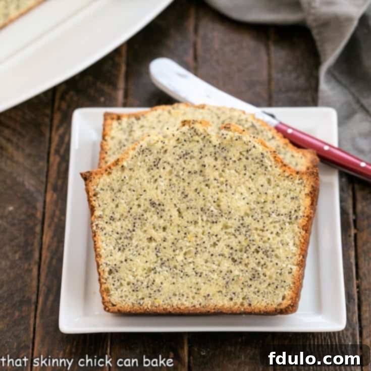 2 slices of lemon poppy seed bread on a square white plate with a red handle knife